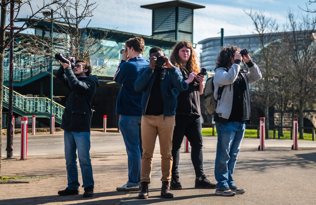 Group of young men taking photographs