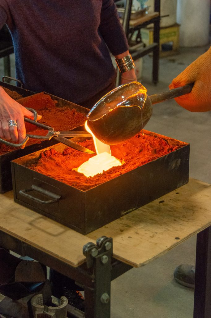 Photograph of molten glass being poured into a mould