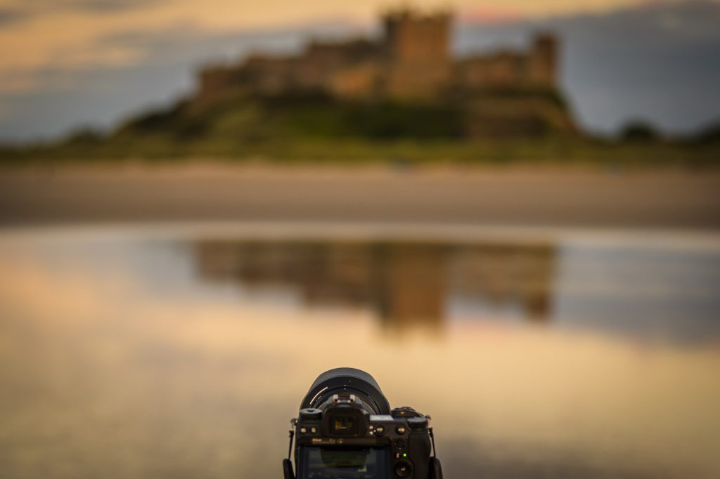 Photograph of a camera in front of Bamburgh Castle